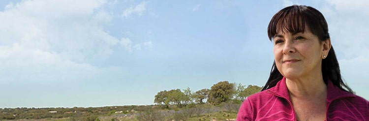 Woman in pink looking into the distance outside